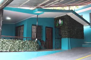 niebieski dom z zieloną ścianą i drzwiami w obiekcie Casa Chu en Playa Manuel Antonio w mieście Manuel Antonio