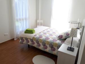 ein Schlafzimmer mit einem Bett und einem Tisch mit einem Stuhl in der Unterkunft Apartamentos Somo1 in Somo