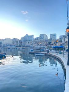 een lichaam van water met boten in een stad bij Malta Crown guesthouse in St Julian's