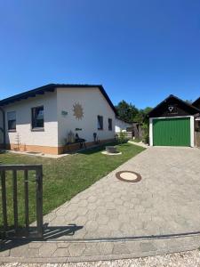 Ferienhaus 40 في Egloffstein: منزل مع مرآب أخضر وممر