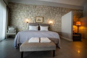 a bedroom with a bed with two towels on a bench at Zena Hotel Alaçatı Adults Only in Alaçatı