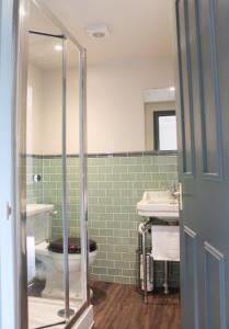 uma casa de banho com um chuveiro e um lavatório. em The George Inn St Mary Bourne em Saint Mary Bourne
