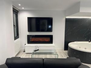 a living room with a fireplace and a tv at Black and White Suite Castro Urdiales in Castro-Urdiales