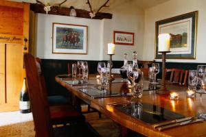 a long table in a restaurant with glasses on it at The George Inn St Mary Bourne in Saint Mary Bourne