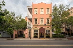 a pink building with two flags on a street at Meeting Street Inn in Charleston