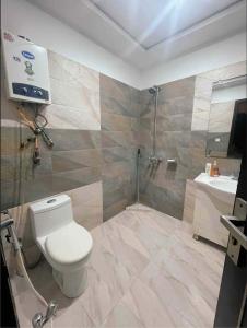 a bathroom with a toilet and a shower and a sink at Luxury Private Top Floor Apartment in Heart of Bahria Town in Lahore