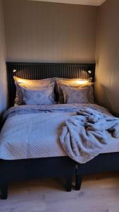 a bedroom with a bed with a blanket on it at Midt i Drammen - supersentralt og gratis parkering in Drammen