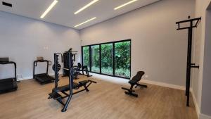 einen Fitnessraum mit Trainingsgeräten und einem großen Fenster in der Unterkunft Loft Amplo e Aconchegante c/ Quarto Privativo in Campo Grande