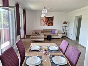 ein Esszimmer mit einem Tisch und lila Stühlen in der Unterkunft Val&Sol Apartments in Sečovlje