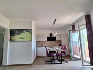 a kitchen and dining room with a table and chairs at Val&Sol Apartments in Sečovlje