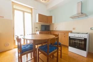 a kitchen with a wooden table with chairs and a stove at Casa Vinicia in Equi Terme