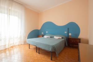 a bedroom with a bed with a blue headboard at Casa Vinicia in Equi Terme