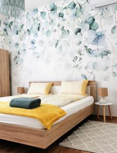 歐爾菲的住宿－Life Apartman Orfű，一间卧室配有一张带花卉墙壁的床