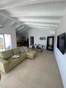 een woonkamer met een bank en een tafel bij Villa Lorisa in Tanaunella