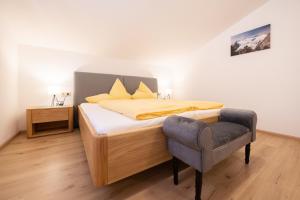 a bedroom with a bed with a chair in it at Haus Mary in Neustift im Stubaital