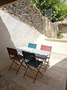 een tafel en 4 stoelen op een patio bij Charmante maison de village in Caumont-sur-Durance