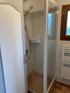 een badkamer met een douche en een glazen deur bij Gîte de charme La Pocterie in Vouneuil-sur-Vienne
