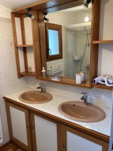 een badkamer met 2 wastafels en een spiegel bij Gîte de charme La Pocterie in Vouneuil-sur-Vienne