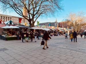 um grupo de pessoas andando em torno de um mercado com guarda-chuvas em Peaceful Norfolk Broads 1 Bedroom 2 bath annexe em Halvergate