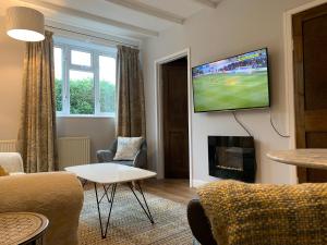 uma sala de estar com uma televisão na parede em Peaceful Norfolk Broads 1 Bedroom 2 bath annexe em Halvergate