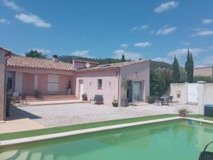 a house with a swimming pool in front of it at L’Echappée Belle in Saint-Jean-de-Fos