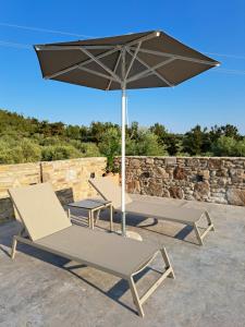 two chairs and an umbrella on a patio at OliVISTA - Live in Nature in Astris