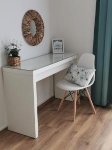 a white desk with a chair and a pillow at Life Apartman Orfű in Orfű