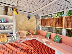 Cette chambre comprend un canapé, une table et des chaises. dans l'établissement Racoco Villa -Apartment, à Jambiani