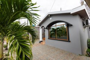 a house with a brick walkway next to a window at Tropical Paradise, Galápagos in Puerto Baquerizo Moreno