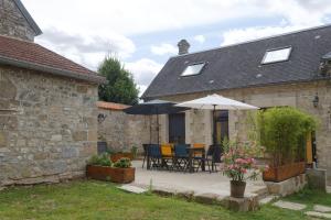 a patio with tables and umbrellas in front of a house at La Bohème in Paissy