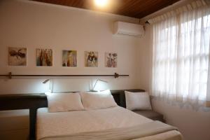 a bedroom with a bed with two pillows and a window at Apartamento Kami in Porto Alegre