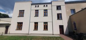 Una casa blanca con muchas ventanas. en Apartament Starówka, en Konin