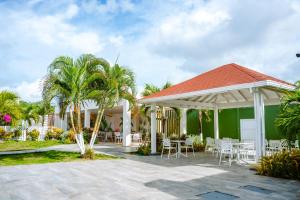 a patio with white chairs and palm trees at Hotel Koray in San Andrés