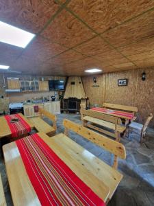 a kitchen with wooden tables and benches in a room at Rebeka Guest House in Tryavna