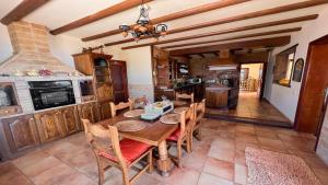 uma sala de jantar com uma mesa de madeira e uma cozinha em Preciosa Casa Cristian y María con piscina privada em Tías
