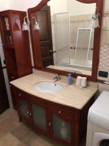 ein Bad mit einem Waschbecken und einem Spiegel in der Unterkunft VILLA MARILENA in Andriace