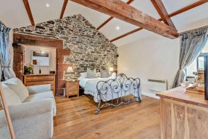 1 dormitorio con cama y pared de piedra en Highside Farm, en Bassenthwaite