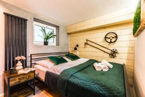 a bedroom with a bed and a wooden wall at Apartament Żubry z Sauna in Zakopane
