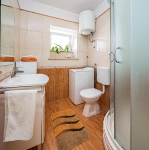 a bathroom with a white toilet and a sink at House Gita in Sutivan
