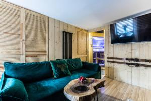 a living room with a green couch and a table at Apartament Żubry z Sauna in Zakopane