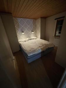 um pequeno quarto com uma cama num quarto em Trivsam stuga i foskros / idre em Idre