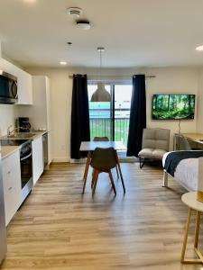 een keuken en een woonkamer met een tafel en een bed bij APPART-HOTEL L'UNI in Québec