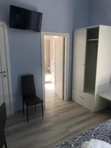 a bedroom with a black chair and a mirror at Domus Gieffe in Tropea +39 photos