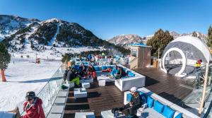 a group of people sitting on a deck in the snow at Prime Loft LA RIOJA in Azarrulla