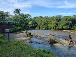 Un río con una señal en el medio. en Casa hospedaje mayesty, en San Cipriano