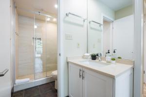 a bathroom with a white sink and a shower at Wildwood Lodge by Outpost Whistler in Whistler