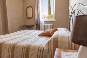 una camera da letto con un letto con una coperta e una finestra di Le Bianchette Agriturismo e Fattoria Didattica a Sommacampagna Altre 37 foto