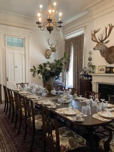 uma sala de jantar com uma mesa longa com cadeiras em The Belmont 1857 em Wayside