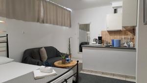 a living room with a couch and a kitchen at Studio V3st & Parking in Larisa