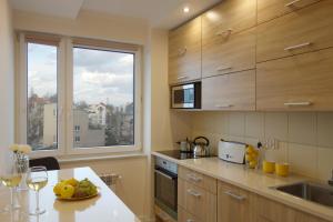 a kitchen with a table with a bowl of fruit on it at Horizon Lu Apartment by the Sea in Sopot